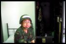 wmw wearing helmet on bed in bunk with locker, horizontal