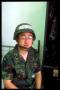 wmw wearing helmet on bed in bunk with locker, eyes closed, vertical