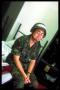 wmw wearing helmet on bed in bunk with locker, diagonal