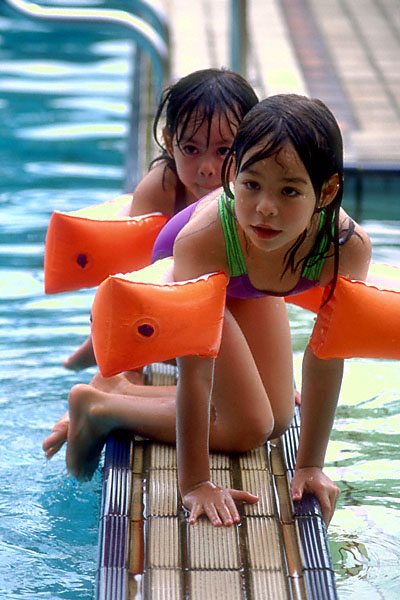coco and kimber astride the pool divider, better