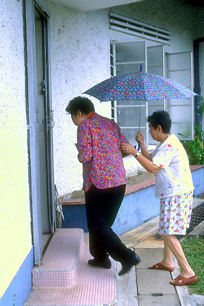 au sook ching (ku mar) guides aunty maggie in from the rain