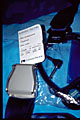 captioned image of plane ticket stub seen with seat belt buckle and headphones in seat