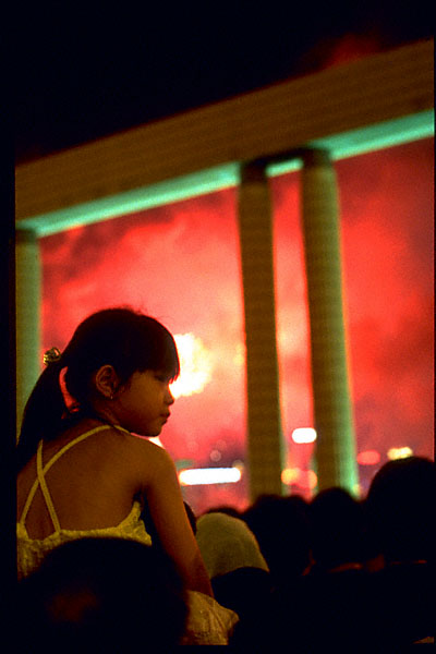 young chinese girl with ponytail against red fireworks smoke