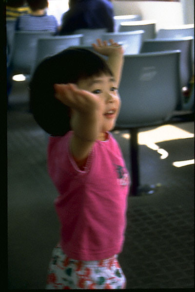 carefree: wong oi yin with arms upraised on deck of ferry to lamma island