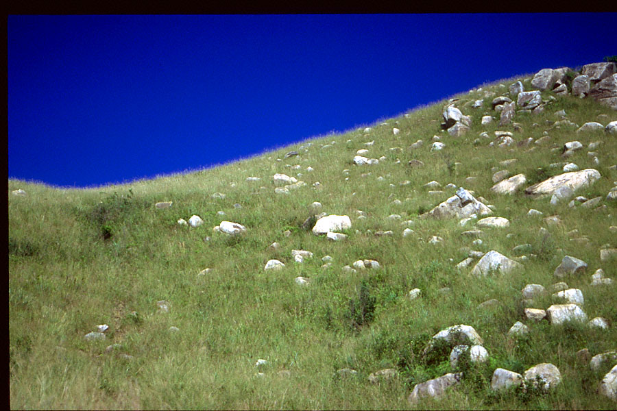 deep blue sky and rocks on hill field