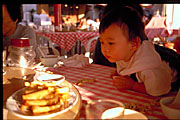 wong seng chak leaning inquisitively across red checkered tablecloth